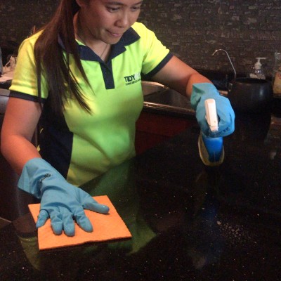 A lady cleaning a table