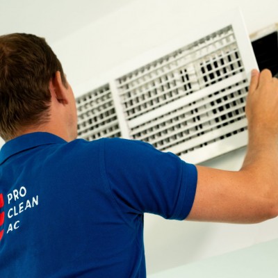 A member of the Pro Clean AC team removing an AC grille to clean it