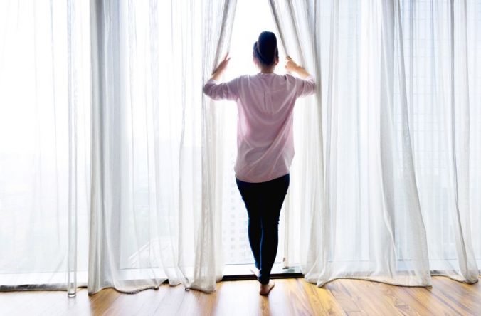 A person standing in front of a curtain
