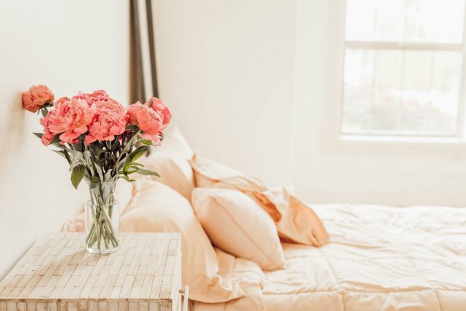 A vase of flowers sitting on a bed